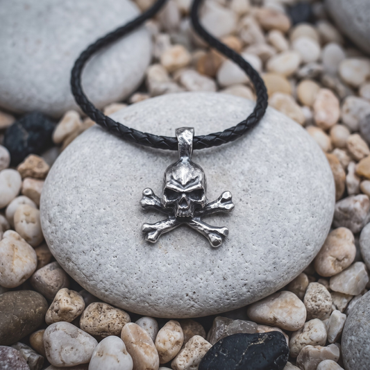 No Master necklace in .999 fine silver — a skull over crossed bones with dark eyes, on a black braided leather cord